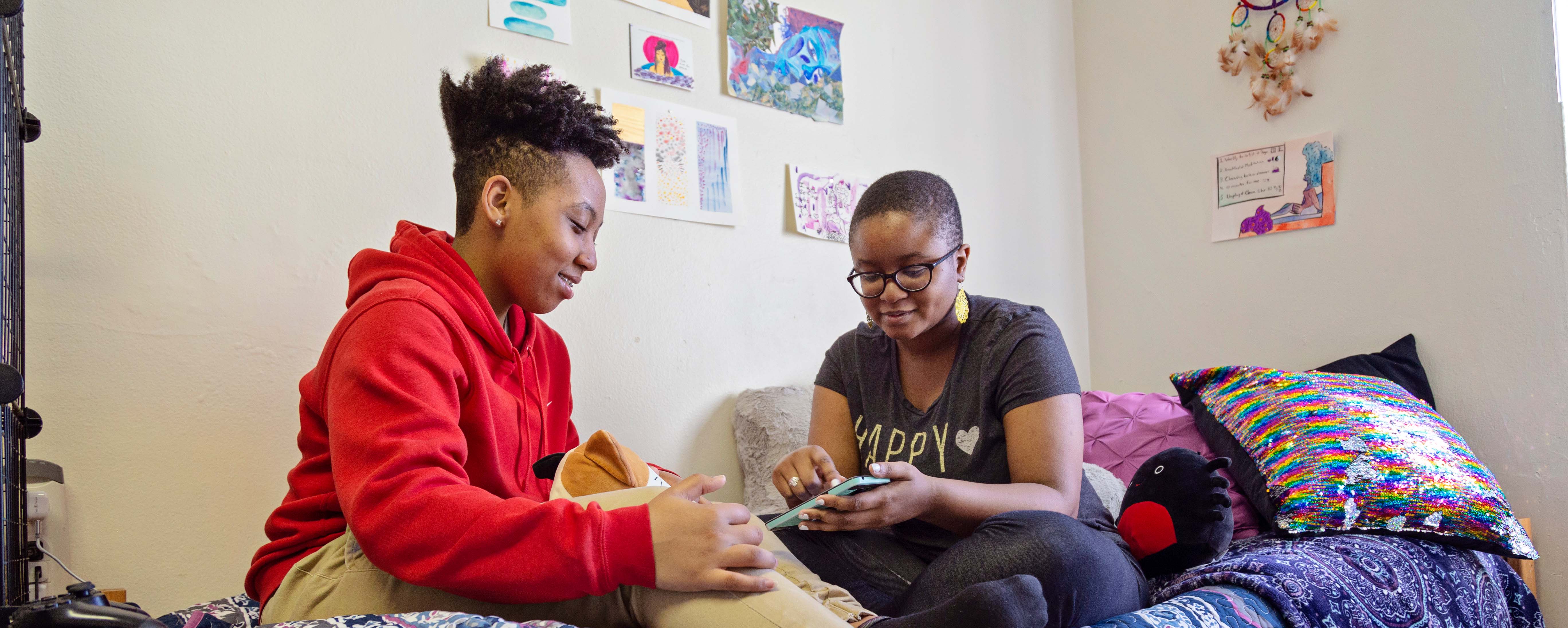 2 students sitting together smiling